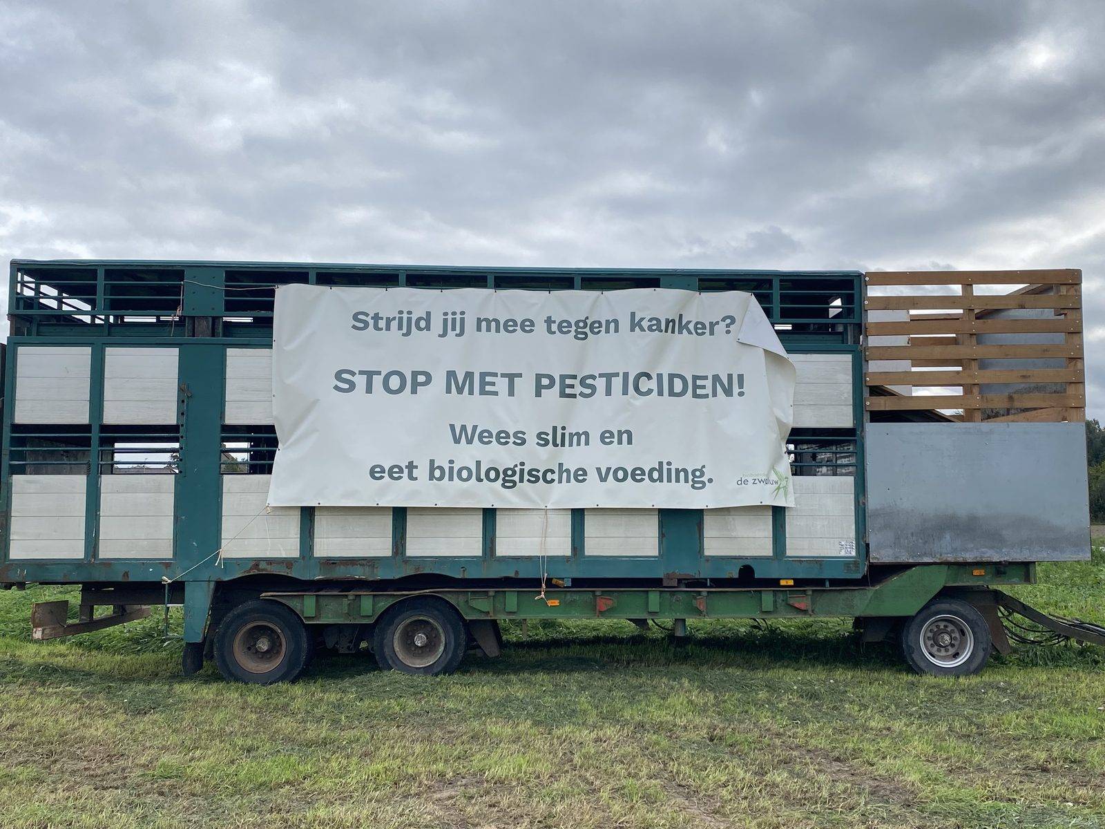 Spandoek "Stop met pesticiden" van bioboerderij De Zwaluw op de velden in Lievegem